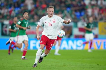 Nov 22, 2022; Doha, Qatar; Poland defender Kamil Glik (15) moves the ball during the second half against Mexico in a group stage match at the 2022 World Cup at Stadium 974. Mandatory Credit: Danielle Parhizkaran-USA TODAY Sports