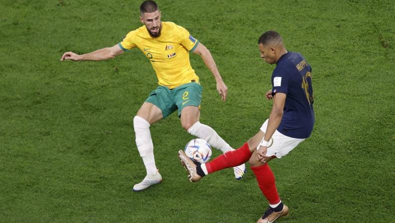 Nov 22, 2022; Al Wakrah, Qatar; France forward Kylian Mbappe (10) passes the ball while defended by Australia defender Milos Degenek (2) during the second half in a group stage match during the 2022 World Cup at Al Janoub Stadium. Mandatory Credit: Yukihito Taguchi-USA TODAY Sports