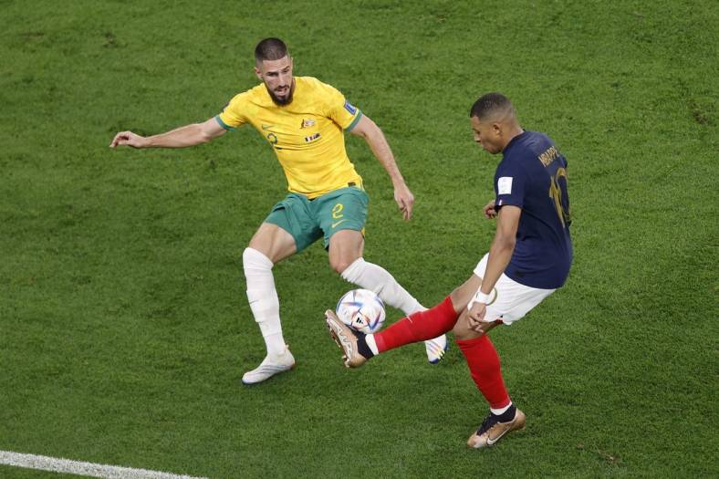 Nov 22, 2022; Al Wakrah, Qatar; France forward Kylian Mbappe (10) passes the ball while defended by Australia defender Milos Degenek (2) during the second half in a group stage match during the 2022 World Cup at Al Janoub Stadium. Mandatory Credit: Yukihito Taguchi-USA TODAY Sports