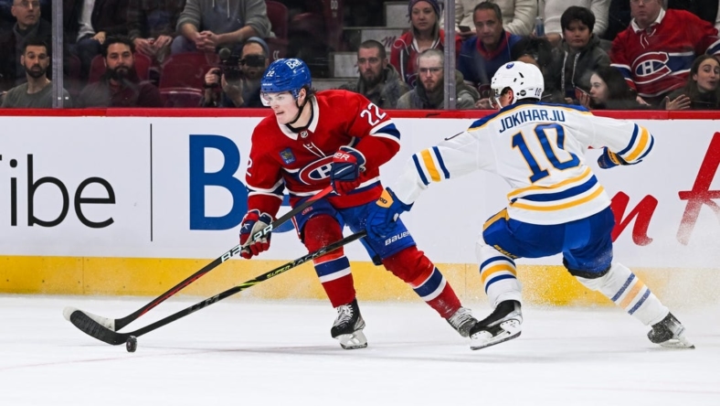 Nov 22, 2022; Montreal, Quebec, CAN; Montreal Canadiens right wing Cole Caufield (22) plays the puck against Buffalo Sabres defenseman Henri Jokiharju (10) during the first period at Bell Centre. Mandatory Credit: David Kirouac-USA TODAY Sports