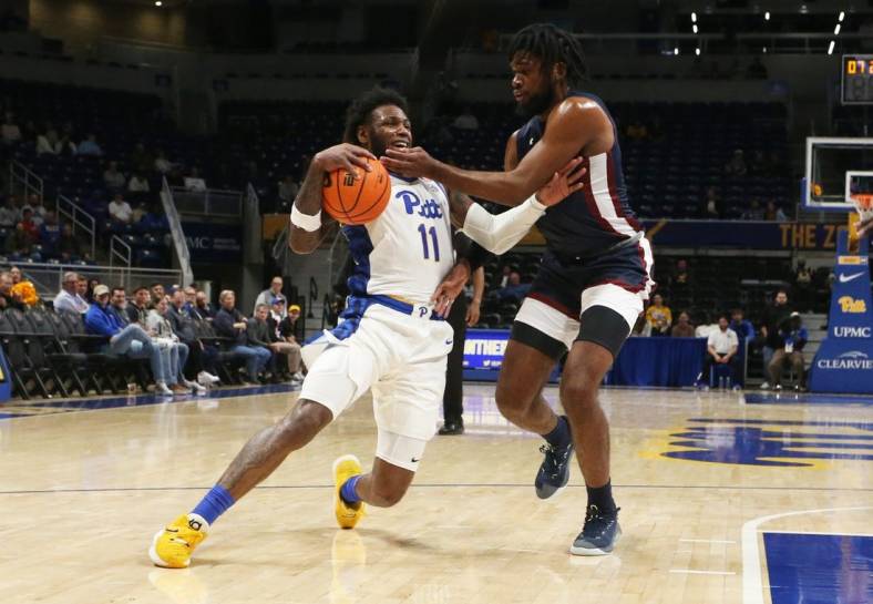 Nov 22, 2022; Pittsburgh, Pennsylvania, USA;  Pittsburgh Panthers guard Jamarius Burton (11) dribbles the ball against Fairleigh Dickinson Knights forward Ansley Almonor (right) during the first half at the Petersen Events Center. Mandatory Credit: Charles LeClaire-USA TODAY Sports