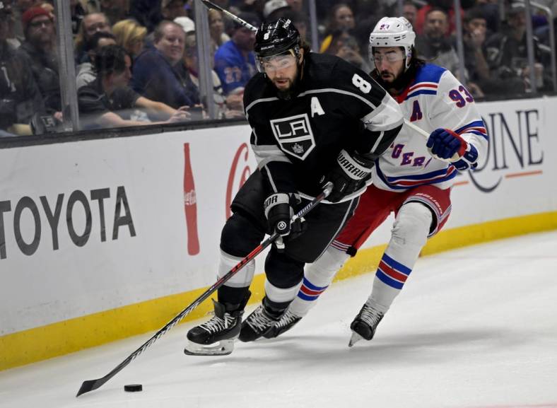 Nov 22, 2022; Los Angeles, California, USA;  Los Angeles Kings defenseman Drew Doughty (8) and New York Rangers center Mika Zibanejad (93) chase down the puck in the first period at Crypto.com Arena. Mandatory Credit: Jayne Kamin-Oncea-USA TODAY Sports