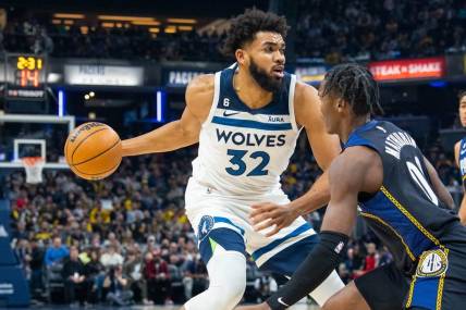 Nov 23, 2022; Indianapolis, Indiana, USA; Minnesota Timberwolves center Karl-Anthony Towns (32) dribbles the ball while Indiana Pacers guard Bennedict Mathurin (00) defends in the first quarter at Gainbridge Fieldhouse. Mandatory Credit: Trevor Ruszkowski-USA TODAY Sports
