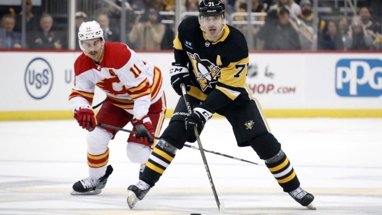Nov 23, 2022; Pittsburgh, Pennsylvania, USA;  Pittsburgh Penguins center Evgeni Malkin (71) skates up ice with the puck ahead of Calgary Flames center Mikael Backlund (11) during the first period at PPG Paints Arena. Mandatory Credit: Charles LeClaire-USA TODAY Sports