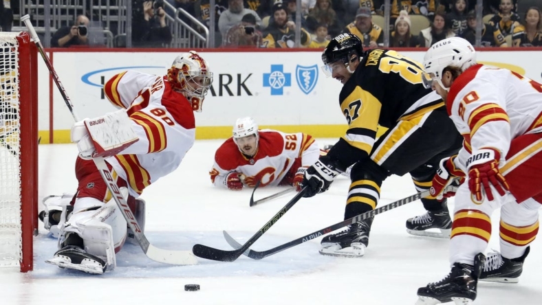 Nov 23, 2022; Pittsburgh, Pennsylvania, USA; Calgary Flames goaltender Dan Vladar (80) defends against Pittsburgh Penguins center Sidney Crosby (87) during the first period at PPG Paints Arena. Mandatory Credit: Charles LeClaire-USA TODAY Sports