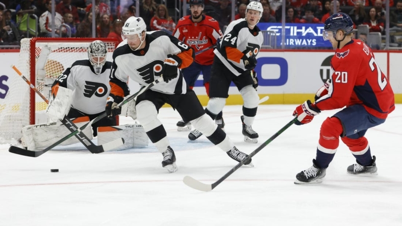 Nov 23, 2022; Washington, District of Columbia, USA; Philadelphia Flyers defenseman Justin Braun (61) clears the puck from in front of Flyers goaltender Felix Sandstrom (32) as Washington Capitals center Lars Eller (20) chases in the first period at Capital One Arena. Mandatory Credit: Geoff Burke-USA TODAY Sports