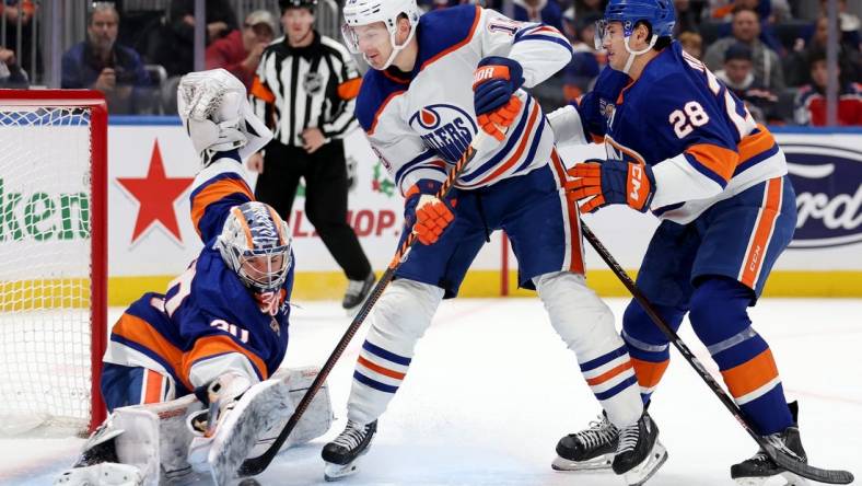 Nov 23, 2022; Elmont, New York, USA; New York Islanders goaltender Ilya Sorokin (30) makes a save against Edmonton Oilers left wing Zach Hyman (18) in front of Islanders defenseman Alexander Romanov (28) during the first period at UBS Arena. Mandatory Credit: Brad Penner-USA TODAY Sports