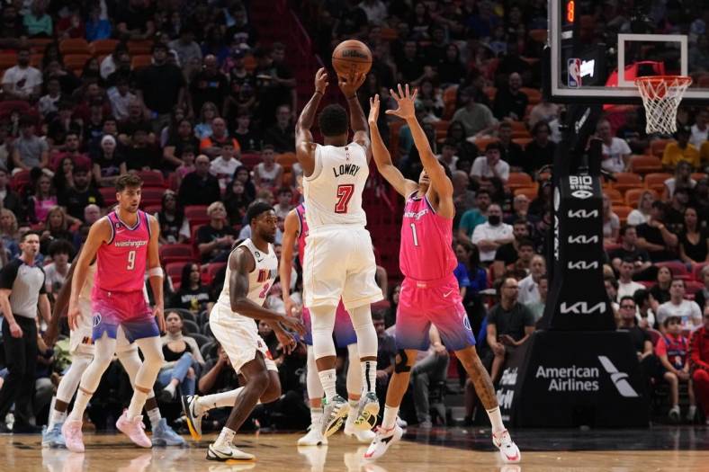 Nov 23, 2022; Miami, Florida, USA; Miami Heat guard Kyle Lowry (7) attempts a three point shot over Washington Wizards guard Johnny Davis (1) during the first half at FTX Arena. Mandatory Credit: Jasen Vinlove-USA TODAY Sports