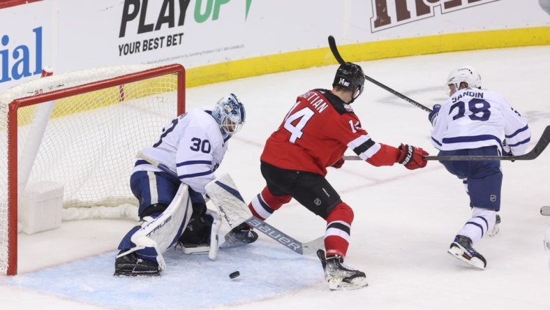 Nov 23, 2022; Newark, New Jersey, USA; Toronto Maple Leafs goaltender Matt Murray (30) makes a save through a screen by New Jersey Devils right wing Nathan Bastian (14) during the third period at Prudential Center. Mandatory Credit: Ed Mulholland-USA TODAY Sports