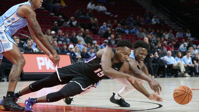 Nov 24, 2022; Portland, Oregon, USA; Portland Pilots forward Chika Nduka (15) and North Carolina Tar Heels guard D'Marco Dunn (11) dive for the ball during the first half at Moda Center. Mandatory Credit: Troy Wayrynen-USA TODAY Sports