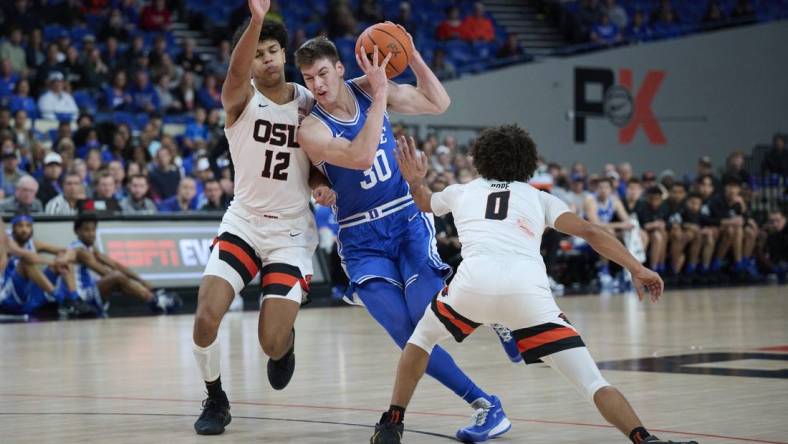 Nov 24, 2022; Portland, Oregon, USA;  Duke Blue Devils center Kyle Filipowski (30) drives to the basket during the first half against Oregon State Beavers forward Michael Rataj (12) and guard Jordan Pope (0) at Veterans Memorial Coliseum. Mandatory Credit: Troy Wayrynen-USA TODAY Sports