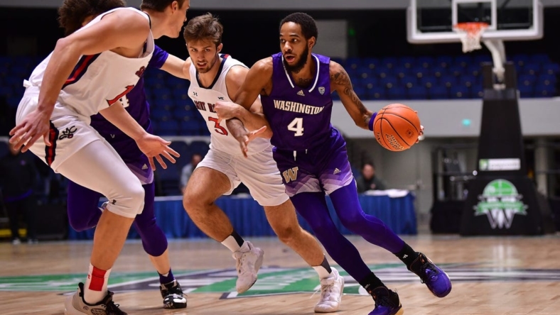 Nov 24, 2022; Anaheim, California, USA; Washington Huskies guard PJ Fuller II (4) moves the ball against St. Mary's Gaels guard Augustas Marciulionis (3) and center Mitchell Saxen (11) during the first half at Anaheim Convention Center. Mandatory Credit: Gary A. Vasquez-USA TODAY Sports