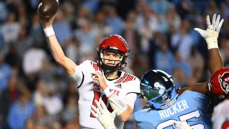 Nov 25, 2022; Chapel Hill, North Carolina, USA; North Carolina State Wolfpack quarterback Ben Finley (10) passes the ball as North Carolina Tar Heels defensive lineman Kaimon Rucker (25) defends in the fourth quarter at Kenan Memorial Stadium. Mandatory Credit: Bob Donnan-USA TODAY Sports