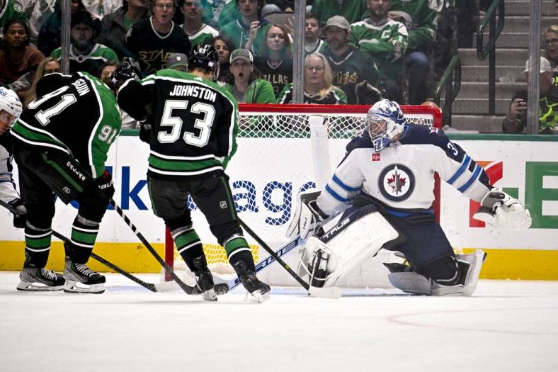 Nov 25, 2022; Dallas, Texas, USA; Winnipeg Jets goaltender Connor Hellebuyck (37) defends against Dallas Stars center Tyler Seguin (91) and center Wyatt Johnston (53) during the third period at the American Airlines Center. Mandatory Credit: Jerome Miron-USA TODAY Sports