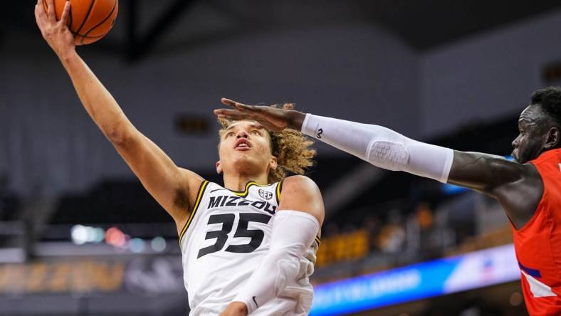 Nov 26, 2022; Columbia, Missouri, USA; Missouri Tigers forward Noah Carter (35) shoots as Houston Christian Huskies center Bonke Maring (4) defends during the second half at Mizzou Arena. Mandatory Credit: Jay Biggerstaff-USA TODAY Sports