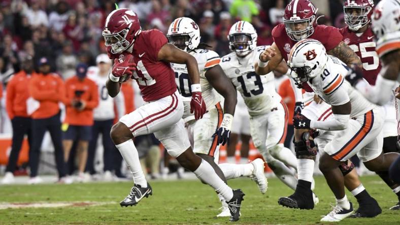 Nov 26, 2022; Tuscaloosa, Alabama, USA; Alabama wide receiver Traeshon Holden (11) breaks away from Auburn defenders including Auburn safety Zion Puckett (10) and Auburn defensive lineman Marcus Harris (50) on his way to a touchdown at Bryant-Denny Stadium. Mandatory Credit: Gary Cosby Jr.-USA TODAY Sports