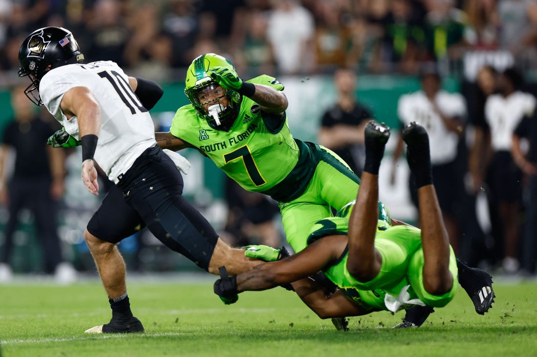 Nov 26, 2022; Tampa, Florida, USA; UCF Knights quarterback John Rhys Plume (10) scrambles with the ball as South Florida Bulls safety Will Jones II (7) defends during the first quarter at Raymond James Stadium. Mandatory Credit: Douglas DeFelice-USA TODAY Sports