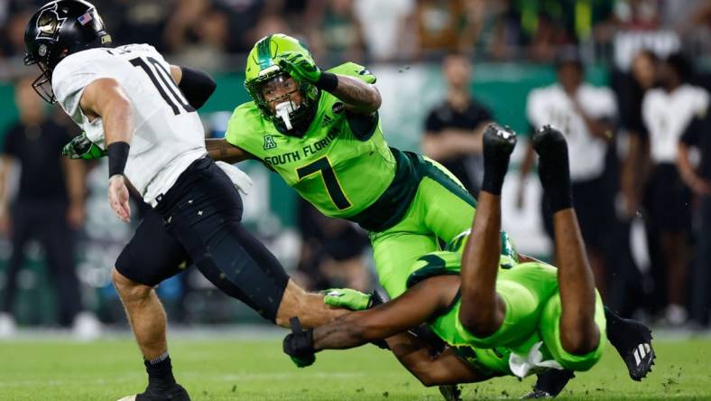 Nov 26, 2022; Tampa, Florida, USA; UCF Knights quarterback John Rhys Plume (10) scrambles with the ball as South Florida Bulls safety Will Jones II (7) defends during the first quarter at Raymond James Stadium. Mandatory Credit: Douglas DeFelice-USA TODAY Sports