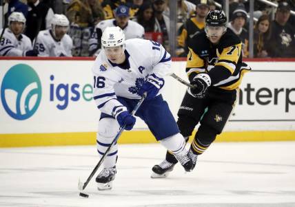 Nov 26, 2022; Pittsburgh, Pennsylvania, USA;  Toronto Maple Leafs right wing Mitchell Marner (16) skates up ice with the puck ahead of Pittsburgh Penguins center Evgeni Malkin (71) during the third period at PPG Paints Arena. Toronto won 4-1. Mandatory Credit: Charles LeClaire-USA TODAY Sports