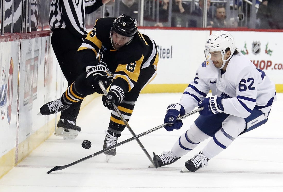 Nov 26, 2022; Pittsburgh, Pennsylvania, USA;  Pittsburgh Penguins defenseman Brian Dumoulin (8) and Toronto Maple Leafs center Denis Malgin (62) battle for the puck during the second period at PPG Paints Arena. Toronto won 4-1. Mandatory Credit: Charles LeClaire-USA TODAY Sports