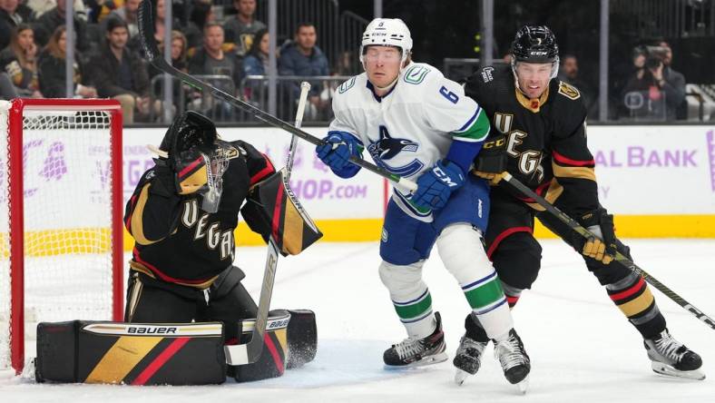 Nov 26, 2022; Las Vegas, Nevada, USA; Vancouver Canucks right wing Brock Boeser (6) and Vegas Golden Knights defenseman Brayden McNabb (3) brace for an incoming shot as Vegas Golden Knights goaltender Logan Thompson (36) makes a glove save during the first period at T-Mobile Arena. Mandatory Credit: Stephen R. Sylvanie-USA TODAY Sports