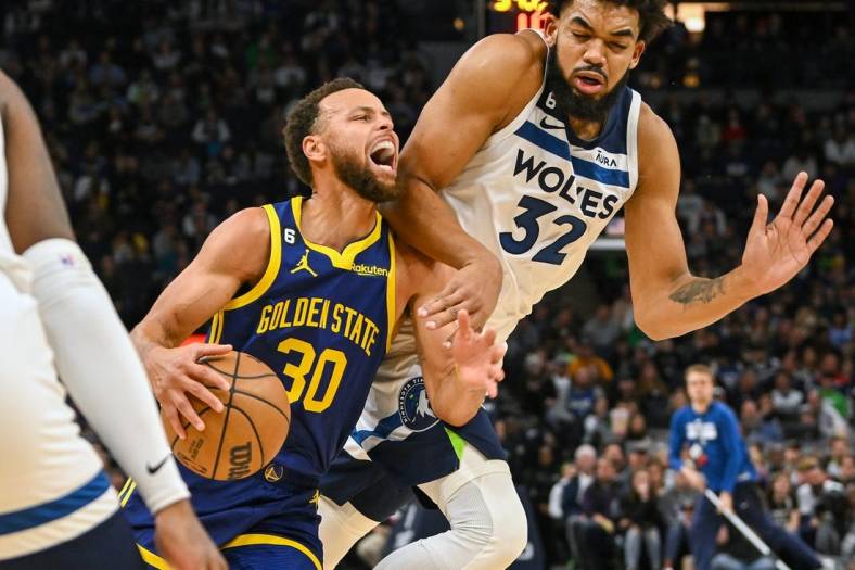 Nov 27, 2022; Minneapolis, Minnesota, USA; Golden State Warriors guard Stephen Curry (30) is called for traveling on this play with Minnesota Timberwolves center Karl-Anthony Towns (32) during the second quarter at Target Center. Mandatory Credit: Nick Wosika-USA TODAY Sports