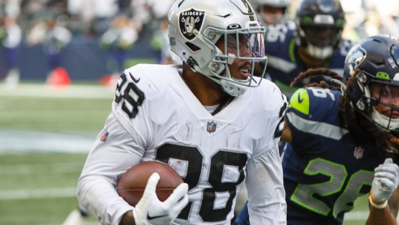 Nov 27, 2022; Seattle, Washington, USA; Las Vegas Raiders running back Josh Jacobs (28) rushes fora touchdown against the Seattle Seahawks during the second quarter at Lumen Field. Mandatory Credit: Joe Nicholson-USA TODAY Sports