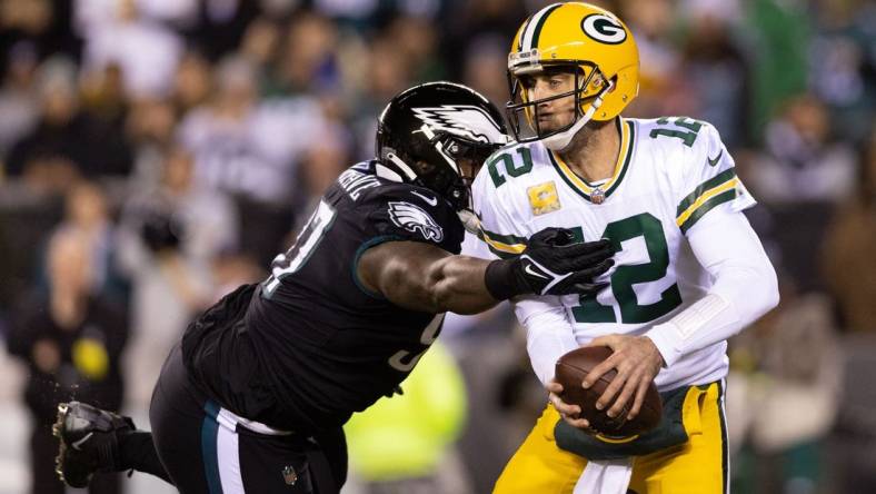 Nov 27, 2022; Philadelphia, Pennsylvania, USA; Green Bay Packers quarterback Aaron Rodgers (12) avoids the tackle attempt of Philadelphia Eagles defensive tackle Javon Hargrave (97) during the first quarter at Lincoln Financial Field. Mandatory Credit: Bill Streicher-USA TODAY Sports