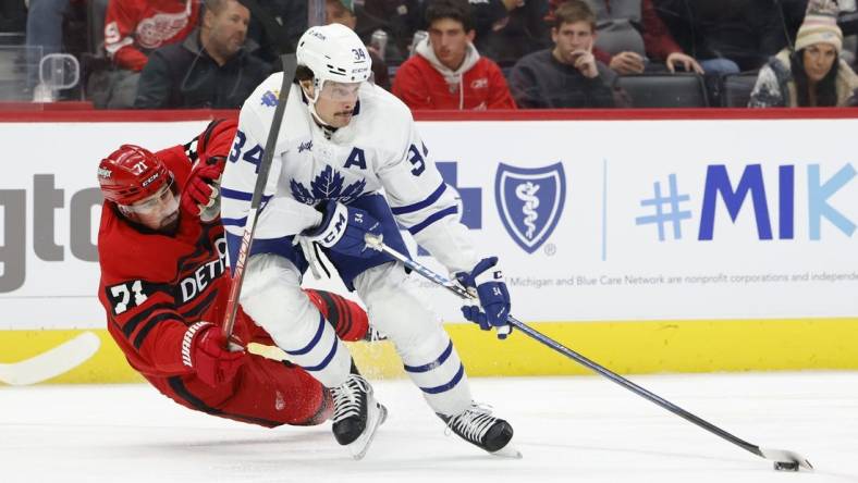 Nov 28, 2022; Detroit, Michigan, USA;  Toronto Maple Leafs center Auston Matthews (34) skates with the puck against Detroit Red Wings center Dylan Larkin (71) in the first period at Little Caesars Arena. Mandatory Credit: Rick Osentoski-USA TODAY Sports