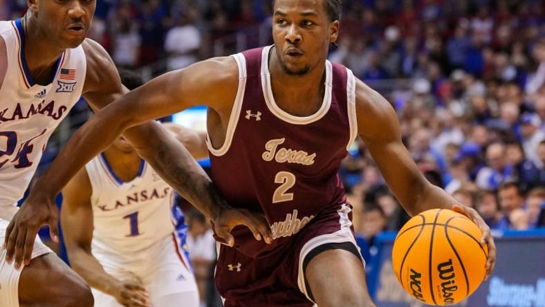 Nov 28, 2022; Lawrence, Kansas, USA; Texas Southern Tigers forward Davon Barnes (2) drives against Kansas Jayhawks forward K.J. Adams Jr. (24) during the first half at Allen Fieldhouse. Mandatory Credit: Jay Biggerstaff-USA TODAY Sports