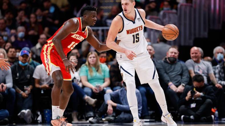 Nov 12, 2021; Denver, Colorado, USA; Denver Nuggets center Nikola Jokic (15) controls the ball as Atlanta Hawks center Clint Capela (15) guards in the third quarter at Ball Arena. Mandatory Credit: Isaiah J. Downing-USA TODAY Sports