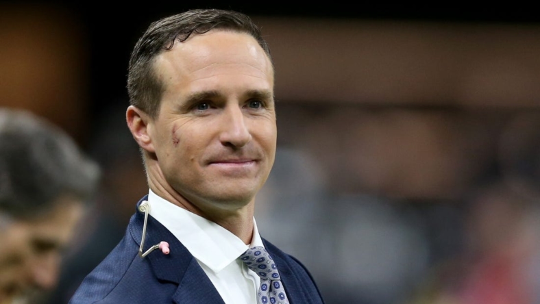 Nov 25, 2021; New Orleans, Louisiana, USA; Former New Orleans Saints quarterback Drew Brees stands on the sidelines before the game between the New Orleans Saints and the Buffalo Bills at the Caesars Superdome. Brees is b being honored at half-time of the game that he is also announcing for NBC. Mandatory Credit: Chuck Cook-USA TODAY Sports