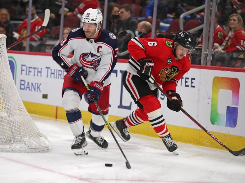 Feb 17, 2022; Chicago, Illinois, USA; Columbus Blue Jackets center Boone Jenner (38) skates away from Chicago Blackhawks defenseman Jake McCabe (6) during the third period at the United Center. Mandatory Credit: Dennis Wierzbicki-USA TODAY Sports