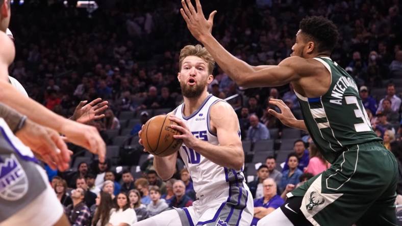 Mar 16, 2022; Sacramento, California, USA; Sacramento Kings center Domantas Sabonis (10) controls the ball against Milwaukee Bucks forward Giannis Antetokounmpo (34) during the first quarter at Golden 1 Center. Mandatory Credit: Kelley L Cox-USA TODAY Sports