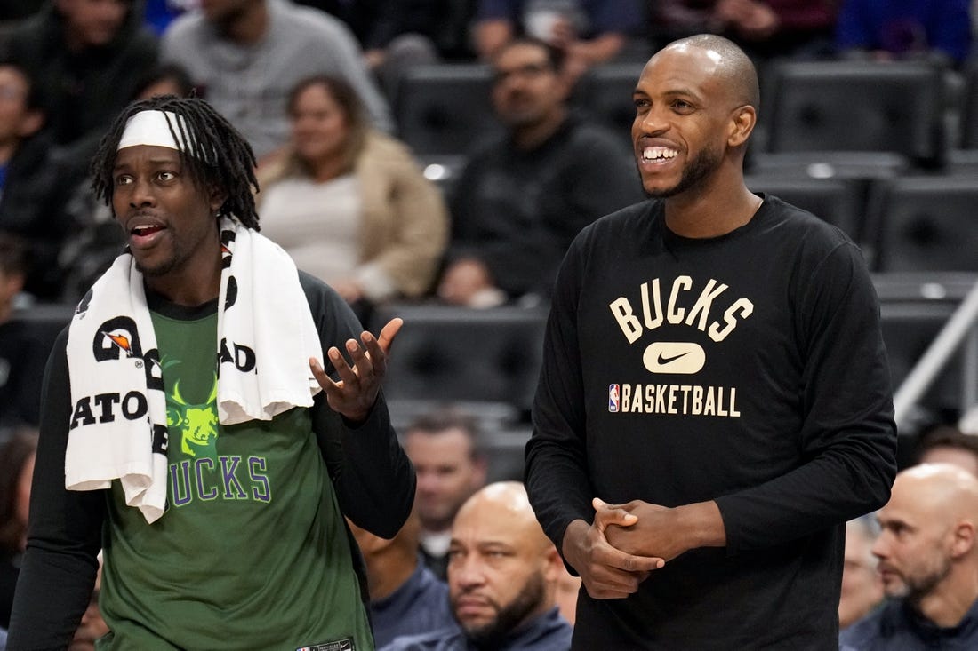 Apr 8, 2022; Detroit, Michigan, USA; Milwaukee Bucks forward Khris Middleton (22) smiles from the bench with guard Jrue Holiday (21) during the fourth quarter at Little Caesars Arena. Mandatory Credit: Raj Mehta-USA TODAY Sports