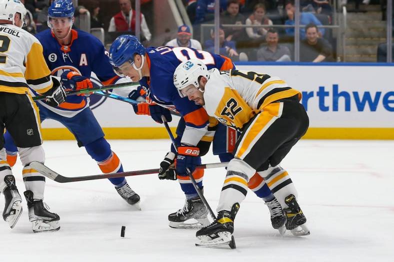 Apr 12, 2022; Elmont, New York, USA; New York Islanders left wing Anders Lee (27) and Pittsburgh Penguins defenseman Mark Friedman (52) battle for the puck at UBS Arena. Mandatory Credit: Tom Horak-USA TODAY Sports