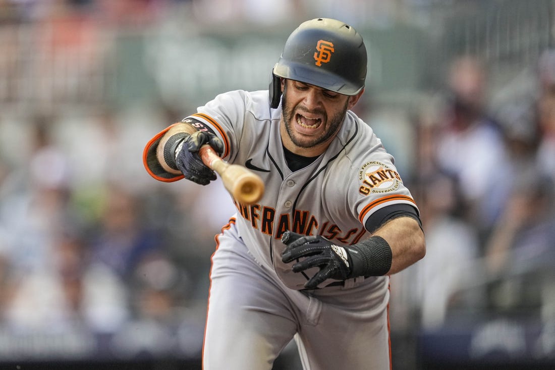 Jun 21, 2022; Cumberland, Georgia, USA; San Francisco Giants designated hitter Tommy La Stella (8) reacts after being hit by a pitch prior to scoring against the Atlanta Braves during the second inning at Truist Park. Mandatory Credit: Dale Zanine-USA TODAY Sports