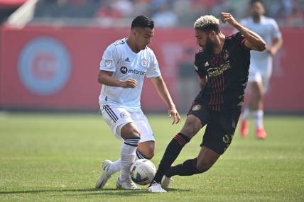 Jul 30, 2022; Chicago, Illinois, USA; Atlanta United FC defender George Campbell (32) moves in to kick the ball away from Chicago Fire FC forward Jairo Torres (7) in the first half at Soldier Field. Mandatory Credit: Jamie Sabau-USA TODAY Sports