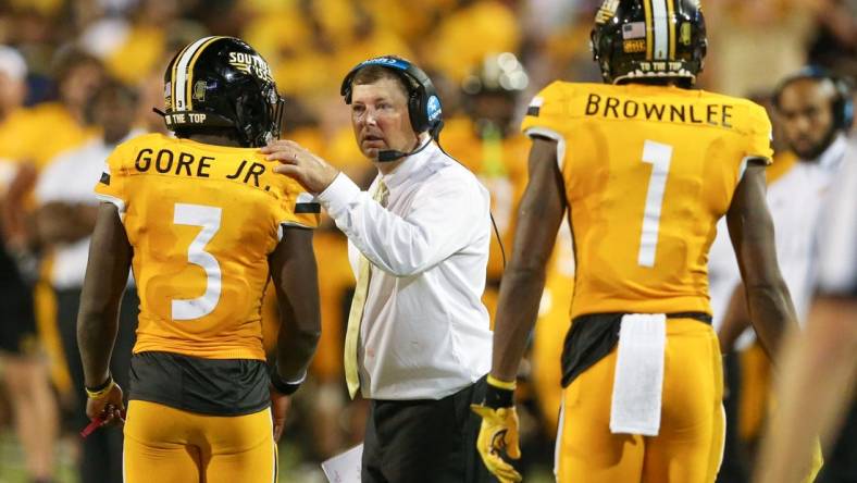 Sep 3, 2022; Hattiesburg, Mississippi, USA; Southern Miss Golden Eagles head coach Will Hall talks to running back Frank Gore Jr. (3) in the second half at M.M. Roberts Stadium. Liberty won in overtime, 29-27. Mandatory Credit: Chuck Cook-USA TODAY Sports