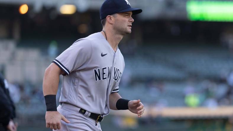 Aug 25, 2022; Oakland, California, USA;  New York Yankees left fielder Andrew Benintendi (18) jogs out from the dugout before the start of the first inning against the Oakland Athletics at RingCentral Coliseum. Mandatory Credit: Stan Szeto-USA TODAY Sports