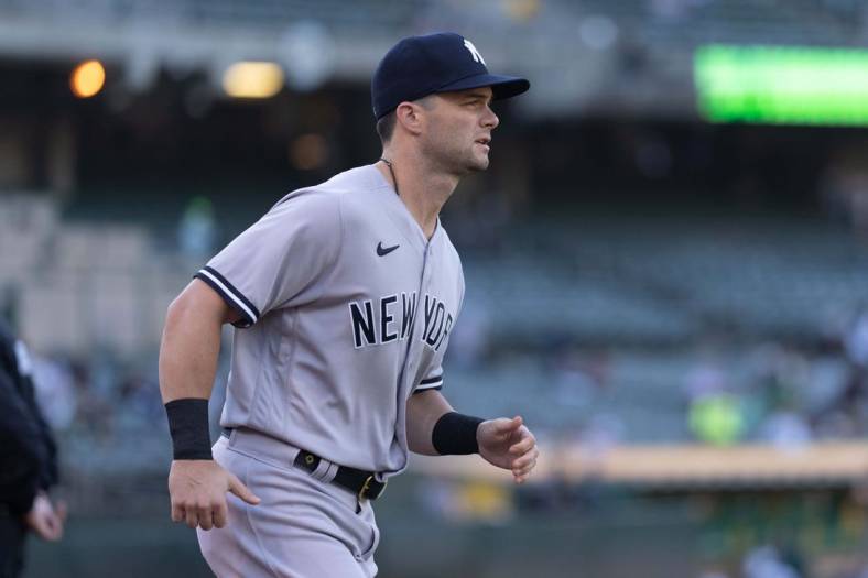 Aug 25, 2022; Oakland, California, USA;  New York Yankees left fielder Andrew Benintendi (18) jogs out from the dugout before the start of the first inning against the Oakland Athletics at RingCentral Coliseum. Mandatory Credit: Stan Szeto-USA TODAY Sports
