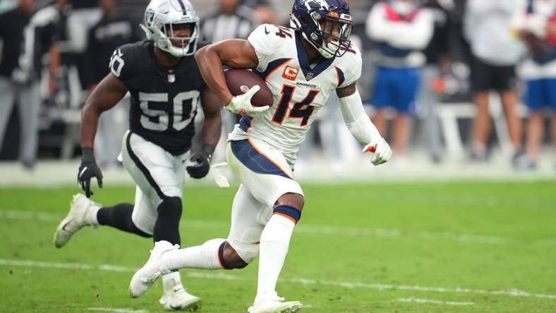 Oct 2, 2022; Paradise, Nevada, USA; Denver Broncos wide receiver Courtland Sutton (14) runs with the ball ahead of Las Vegas Raiders linebacker Jayon Brown (50) during a game at Allegiant Stadium. Mandatory Credit: Stephen R. Sylvanie-USA TODAY Sports