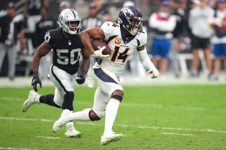 Oct 2, 2022; Paradise, Nevada, USA; Denver Broncos wide receiver Courtland Sutton (14) runs with the ball ahead of Las Vegas Raiders linebacker Jayon Brown (50) during a game at Allegiant Stadium. Mandatory Credit: Stephen R. Sylvanie-USA TODAY Sports