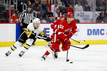 Oct 3, 2022; Detroit, Michigan, USA; Detroit Red Wings defenseman Moritz Seider (53) skates with the puck defended by Pittsburgh Penguins right wing Sam Poulin (22) in the first period at Little Caesars Arena. Mandatory Credit: Rick Osentoski-USA TODAY Sports