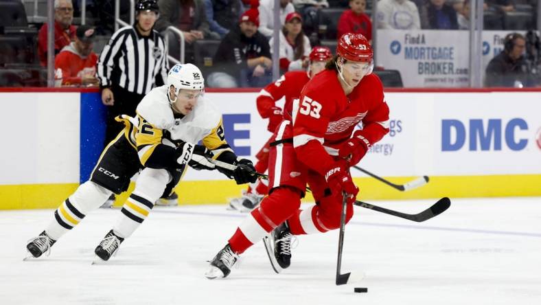 Oct 3, 2022; Detroit, Michigan, USA; Detroit Red Wings defenseman Moritz Seider (53) skates with the puck defended by Pittsburgh Penguins right wing Sam Poulin (22) in the first period at Little Caesars Arena. Mandatory Credit: Rick Osentoski-USA TODAY Sports