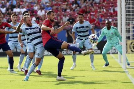 Oct 9, 2022; Frisco, Texas, USA;  FC Dallas defender Matt Hedges (24) shoots on goal as Sporting Kansas City forward Johnny Russell (7) defends during the first half at Toyota Stadium. Mandatory Credit: Kevin Jairaj-USA TODAY Sports