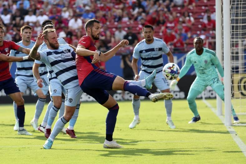 Oct 9, 2022; Frisco, Texas, USA;  FC Dallas defender Matt Hedges (24) shoots on goal as Sporting Kansas City forward Johnny Russell (7) defends during the first half at Toyota Stadium. Mandatory Credit: Kevin Jairaj-USA TODAY Sports