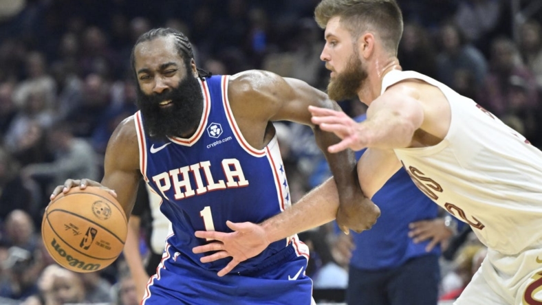 Oct 10, 2022; Cleveland, Ohio, USA; Philadelphia 76ers guard James Harden (1) drives against Cleveland Cavaliers forward Dean Wade (32) in the second quarter at Rocket Mortgage FieldHouse. Mandatory Credit: David Richard-USA TODAY Sports