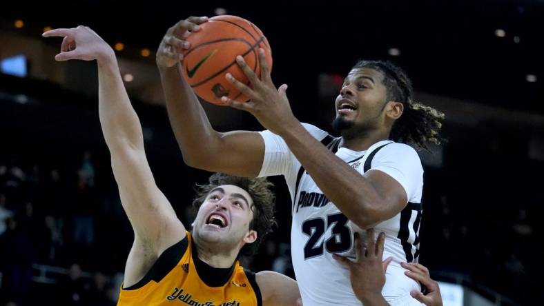 Providence shooter Bryce Hopkins drives in for a lay up over AIC defender Buka Peikrishvili.