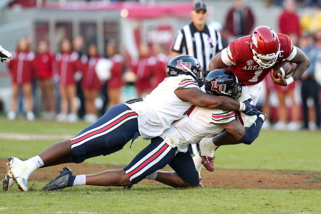 Nov 5, 2022; Fayetteville, Arkansas, USA; Liberty Flames defensive tackle Dre Butler (5) and defensive end Durrell Johnson (11) tackle Arkansas Razorbacks quarterback KJ Jefferson (1) in the second half at Donald W. Reynolds Razorback Stadium. Liberty won 21-19. Mandatory Credit: Nelson Chenault-USA TODAY Sports